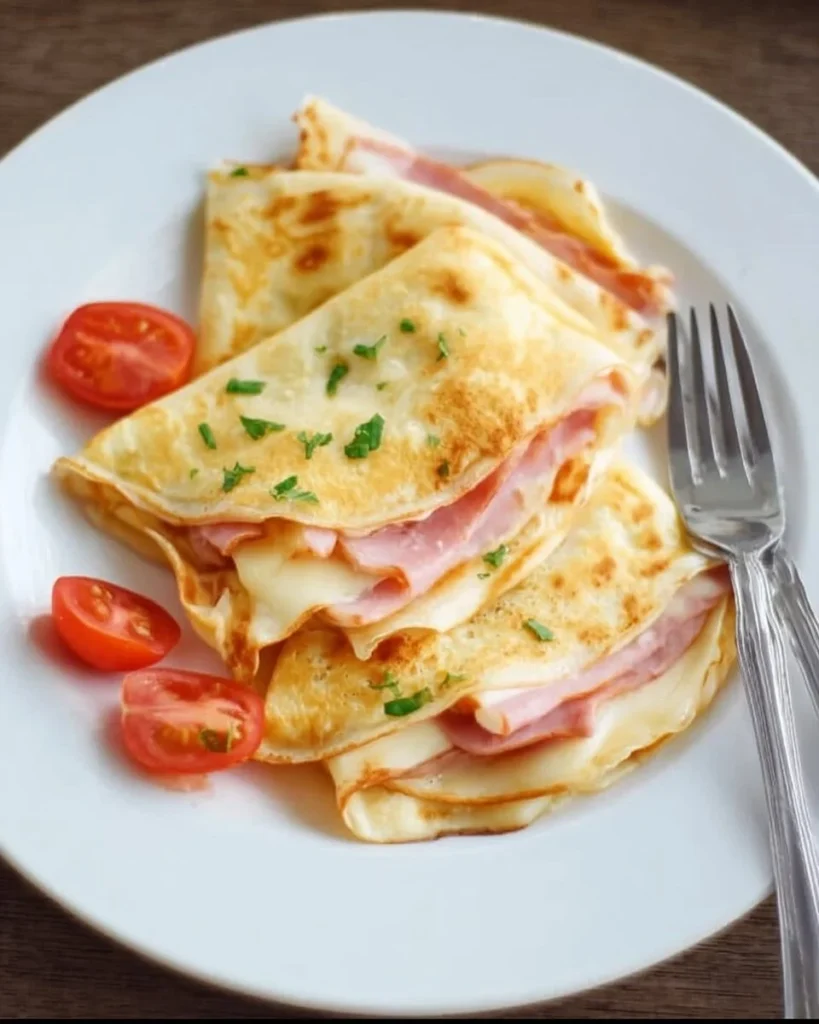 Plate of ham and cheese crepes with fresh herbs