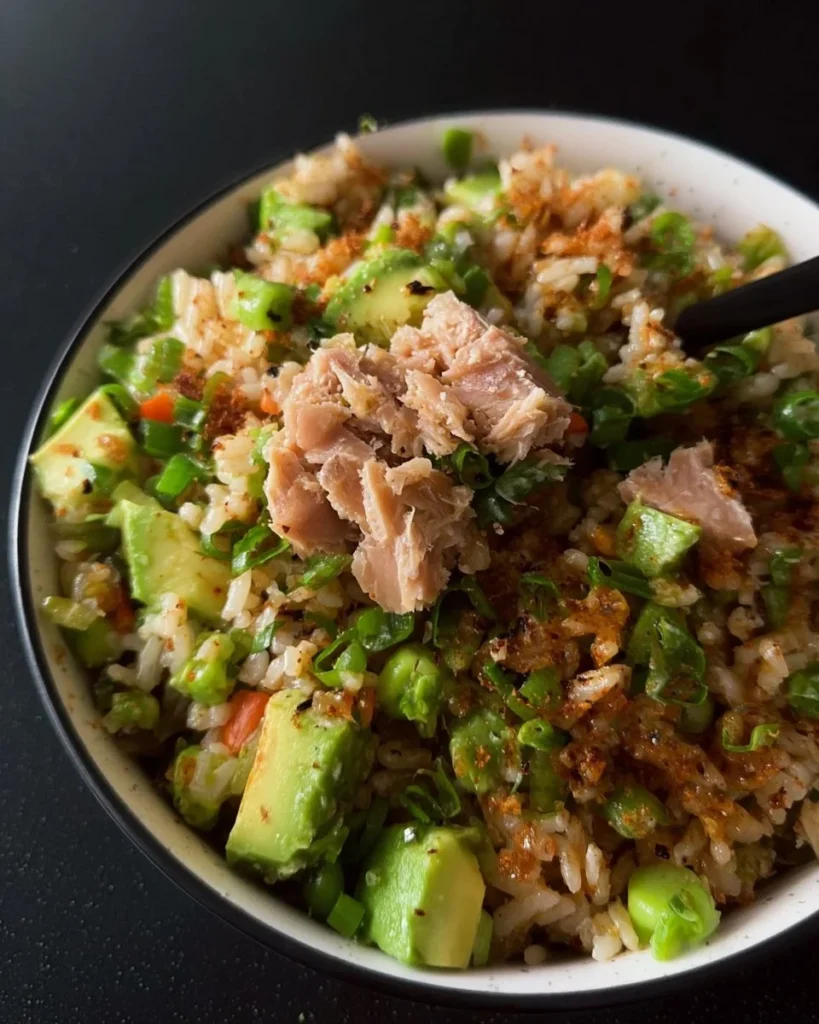 Tuna avocado salad served on crispy rice with fresh ingredients.